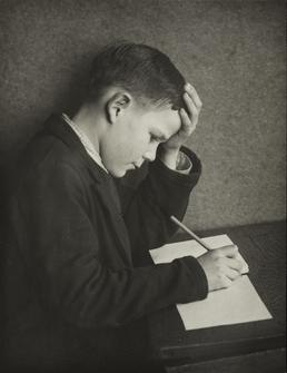 George Titterington, seated at desk with pencil and…