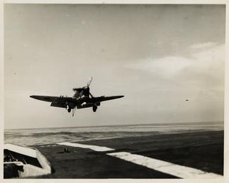Aeroplane approaching HMS Puncher off the Isle of…